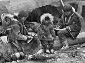 AN ESKIMO FAMILY. Tenderness and responsibility in their treatment of children is a virtue of the Eskimo which binds them closer to the brotherhood of civilized peoples than their skill at carving or with the needle.