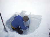 English: A person cutting a sample from a snow pit in order to evaluate the risk of avalanches