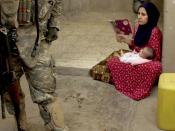 An Iraqi woman looks on as U.S. Army Soldiers from 1st Battalion, 23rd Infantry Regiment, 3rd Stryker Brigade Combat Team search the courtyard of her house during a cordon and search in Ameriyah, Iraq.