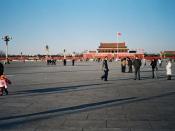 Groups of people wander around Tiananmen Square in the late afternoon.