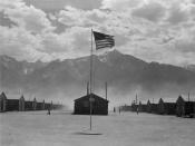 Scene of barrack homes at this War Relocation Authority Center for evacuees of Japanese ancestry. A hot windstorm brings dust from the surrounding desert.