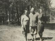 1930 snapshot of parents and their adult daughter, standing outdoors, in fashion of the era.