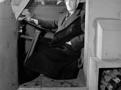 English: Armand Bombardier poses, seated at the wheel of the Bombardier military snowmobile