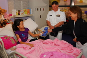 English: HOUSTON (Oct. 27, 2009) Rear Adm. Mark Skinner, program executive officer for Tactical Aircraft Programs, center, and Cmdr. Melanie F. O'Brien, commanding officer of Navy Recruiting District Houston, visit a patient at Texas Children's Hospital d