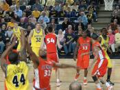 English: Kelvin Grady shoots a jump shot for the Michigan Wolverines men's basketball team in a game against the Illinois Fighting Illini men's basketball team as head coach John Beilein looks on.