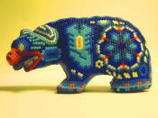 This blue beaded Huichol art bear depicts symbols of peyote, scorpion, and corn.