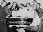 Benny Goodman (third from left) with some of his former musicians, seated around piano left to right: Vernon Brown, George Auld, Gene Krupa, Clint Neagley, Ziggy Elman, Israel Crosby and Teddy Wilson (at piano) / World Telegram & Sun photo by Fred Palumbo