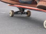 The underside of a skateboard. In this photo the deck, trucks and wheels can be seen.