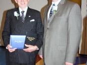 English: David H. Murdock (left) receiving the high school diploma he didn't get. He has in his hands the diplomas from he should have graduated and the 2009 diploma. Next to him is the the high school principal.