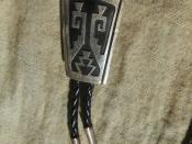 English: A simple silver bolo tie made by Navaho silversmith Tommy Singer purchased in Taos, New Mexico during the 1980's.