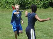 Two runners prepare to pass a baton during a relay race.