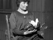 Helen Keller sitting holding a magnolia flower, circa 1920