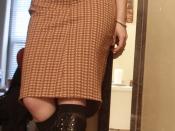 English: A woman wearing a pencil skirt with lace-up boots and a wide belt.