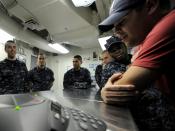 US Navy 101224-N-8824M-092 Sailors aboard the aircraft carrier USS Abraham Lincoln (CVN 72) gather around a telephone speaker for a holiday phone c