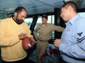 English: Pro Football Hall of Fame running back Franco Harris autographs a football for Yeoman 2nd Class David Lomeli during a tour of the aircraft carrier USS George Washington (CVN 73). The four-time Super Bowl Champion with the Pittsburgh Steelers visi