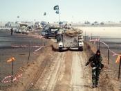 A column of M-113 armored personnel carriers and other military vehicles of the Royal Saudi Land Force travels along a channel cleared of mines during Operation Desert Storm.