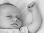 English: A sleeping male baby with his arm extended