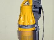 A Dyson DC07 upright cyclonic vacuum cleaner using centrifugal force to separate dust and particles from the air flowing through the cylindrical collection vessel