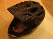 A carbon full-face bicycle helmet intended for downhill racing.