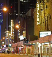 English: Nighttime photo of the Broadway theaters on West 45th Street (George Abbott Way) in New York City. From right to left, the Golden Theater showing Oleanna; the Jacobs Theater showing God of Carnage; the Schoenfeld Theatre showing A Steady Rain, an