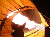 Hot air balloon being inflated by its propane burners prior to a dawn launch.