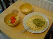 Pasta and pesto, with parmesan cheese (Parmigiano Reggiano) and a little tomato and onion.