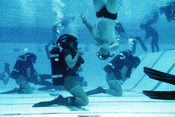 Second phase instructors keep a close eye on Basic Underwater Demolition/SEAL (BUD/S) in the combat training tank. The (BUD/S) are learning to exchange scuba gear while submerged.